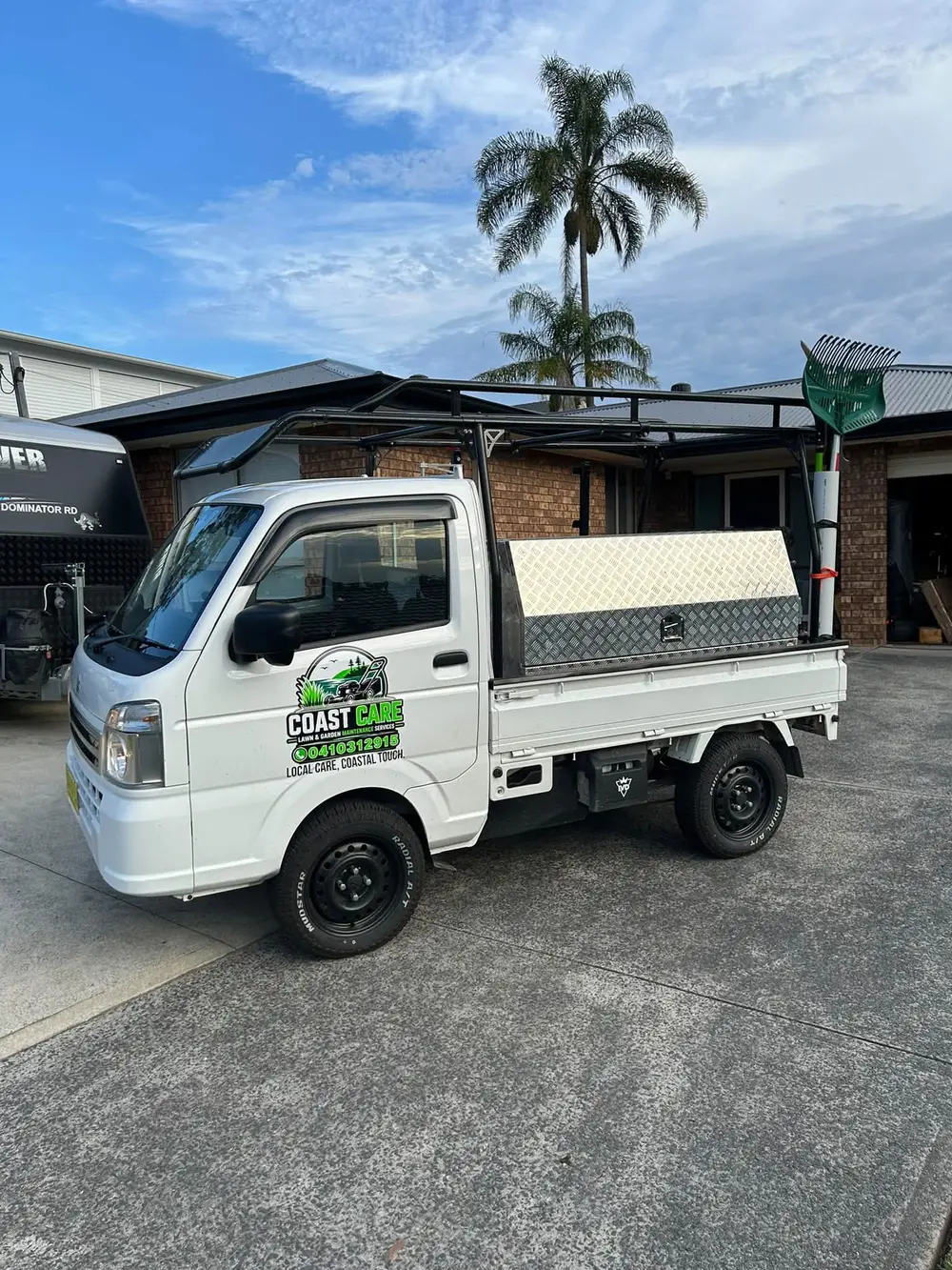 The Coast Care Lawn & Garden Maintenance truck parked on a Central Coast driveway with the mowing gear loaded