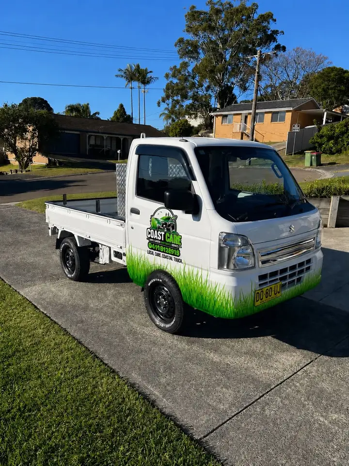 The Coast Care logo and phone number on the side of Christian's white Suzuki truck