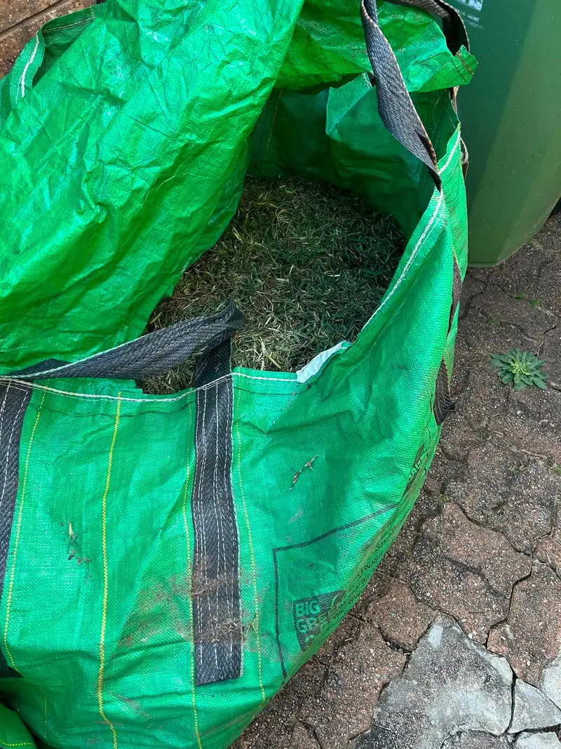 A bulk bag being filled with green waste from a garden tidy-up