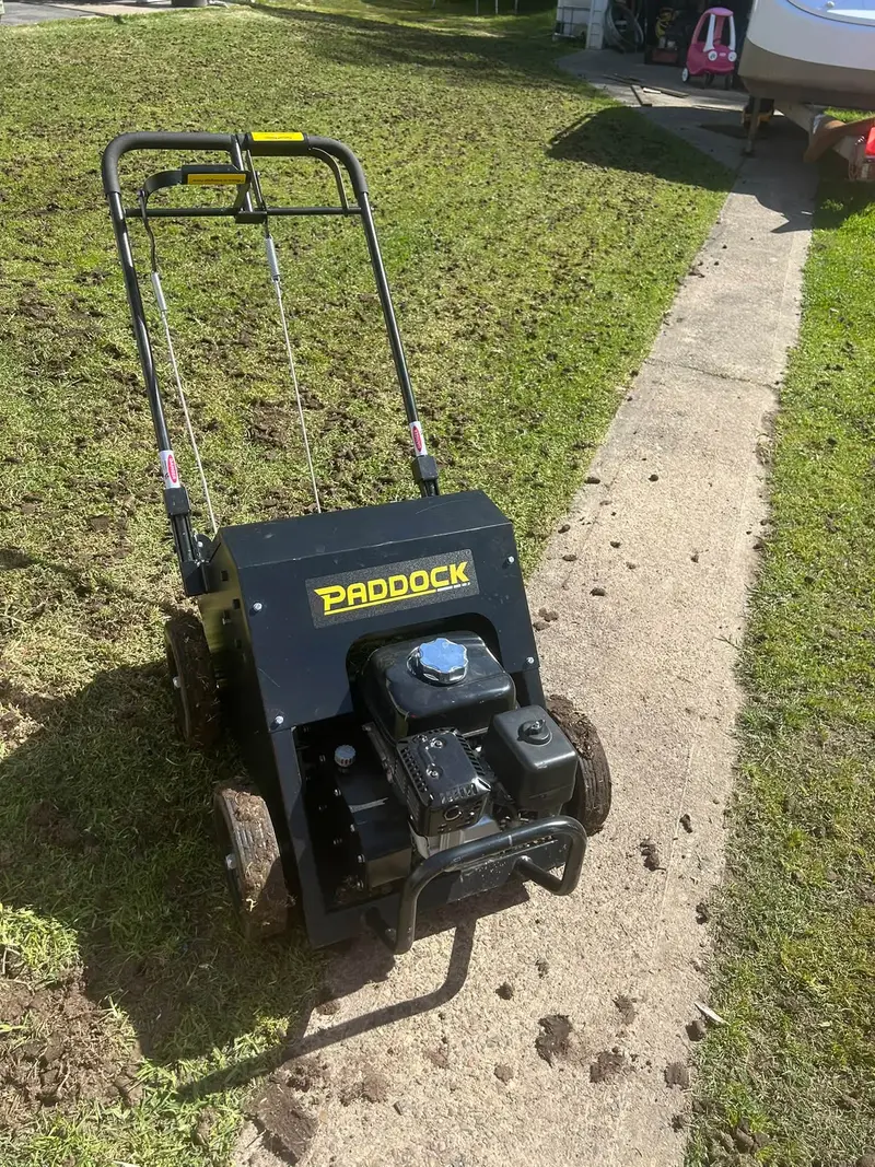 A lawn coring machine working across a lawn, pulling soil plugs